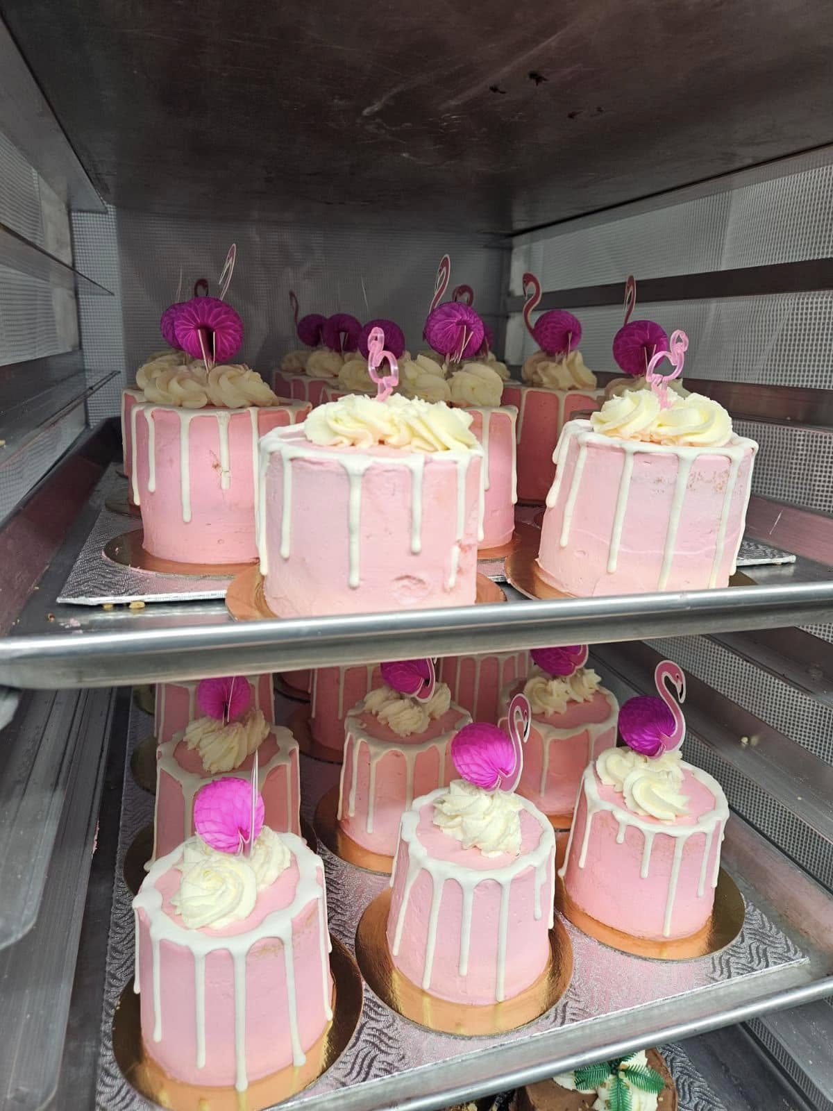 Mini gâteaux flamant rose sur plateaux dans le comptoir à pâtisseries